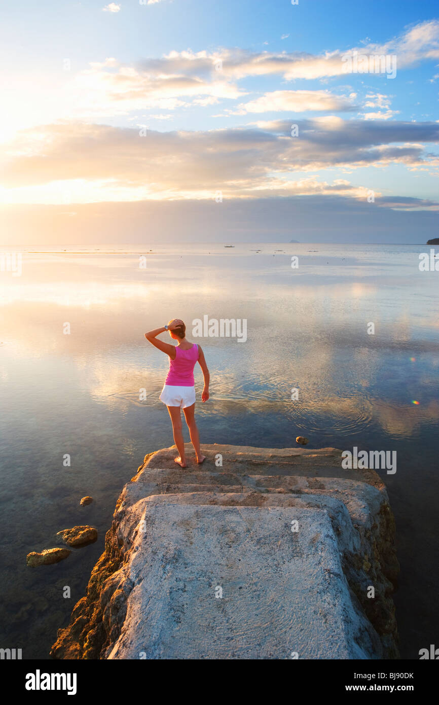 Mädchen stehen am Ende des Piers in Sonnenuntergang Matabungkay suchen; Batangas; SüdLuzon; Philippinen Stockfoto