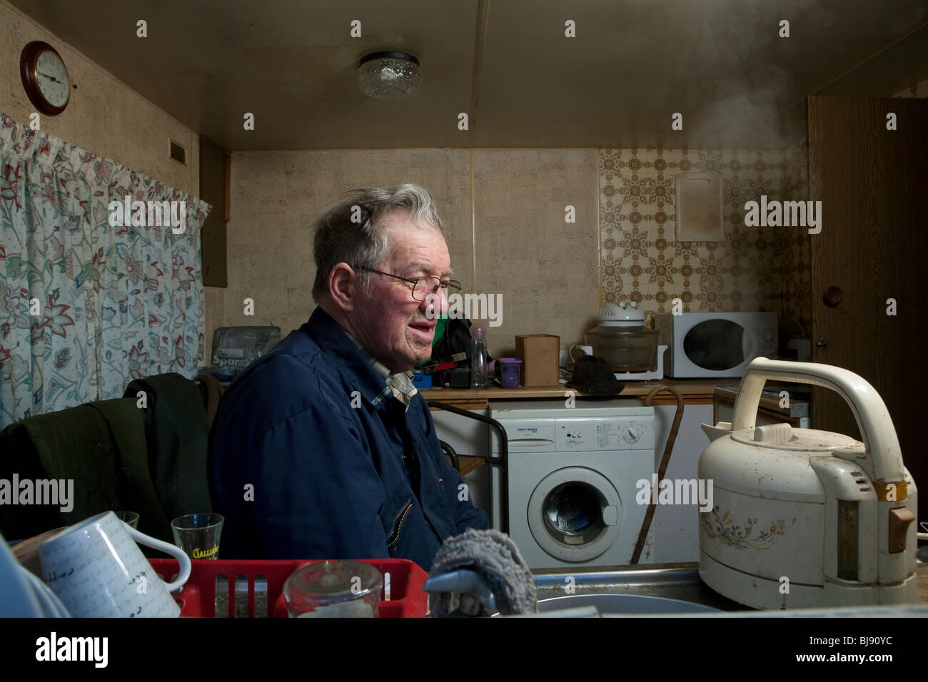 Senior single Mann beobachtet einen Wasserkocher Kochen in seinem Wohnmobil Stockfoto