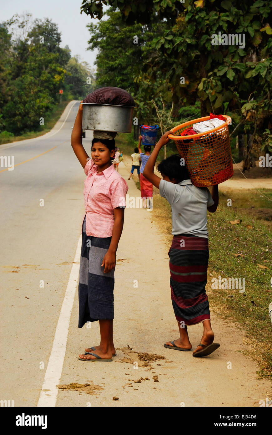 Karen Damen beim Überqueren der Straße mit ihrer Wäsche, Mae la Flüchtlingslager (thai-burmesischen Grenze), nördlich von Mae Sot, thailand Stockfoto