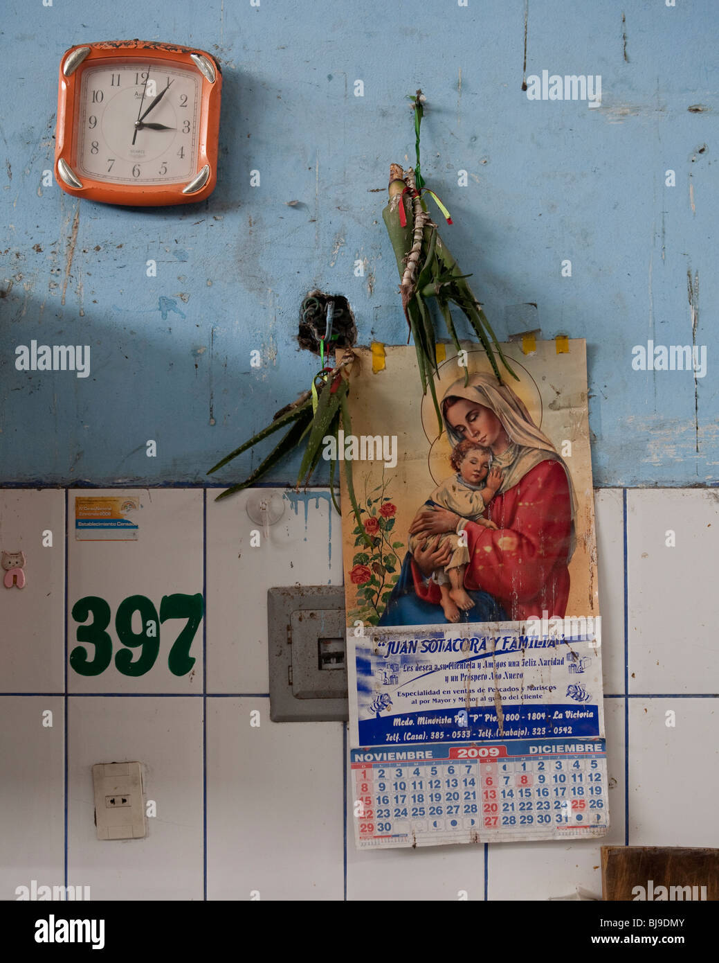 religiöse Motiv Kalender an der Wand der Metzgerei Markt mit Uhr Stockfoto