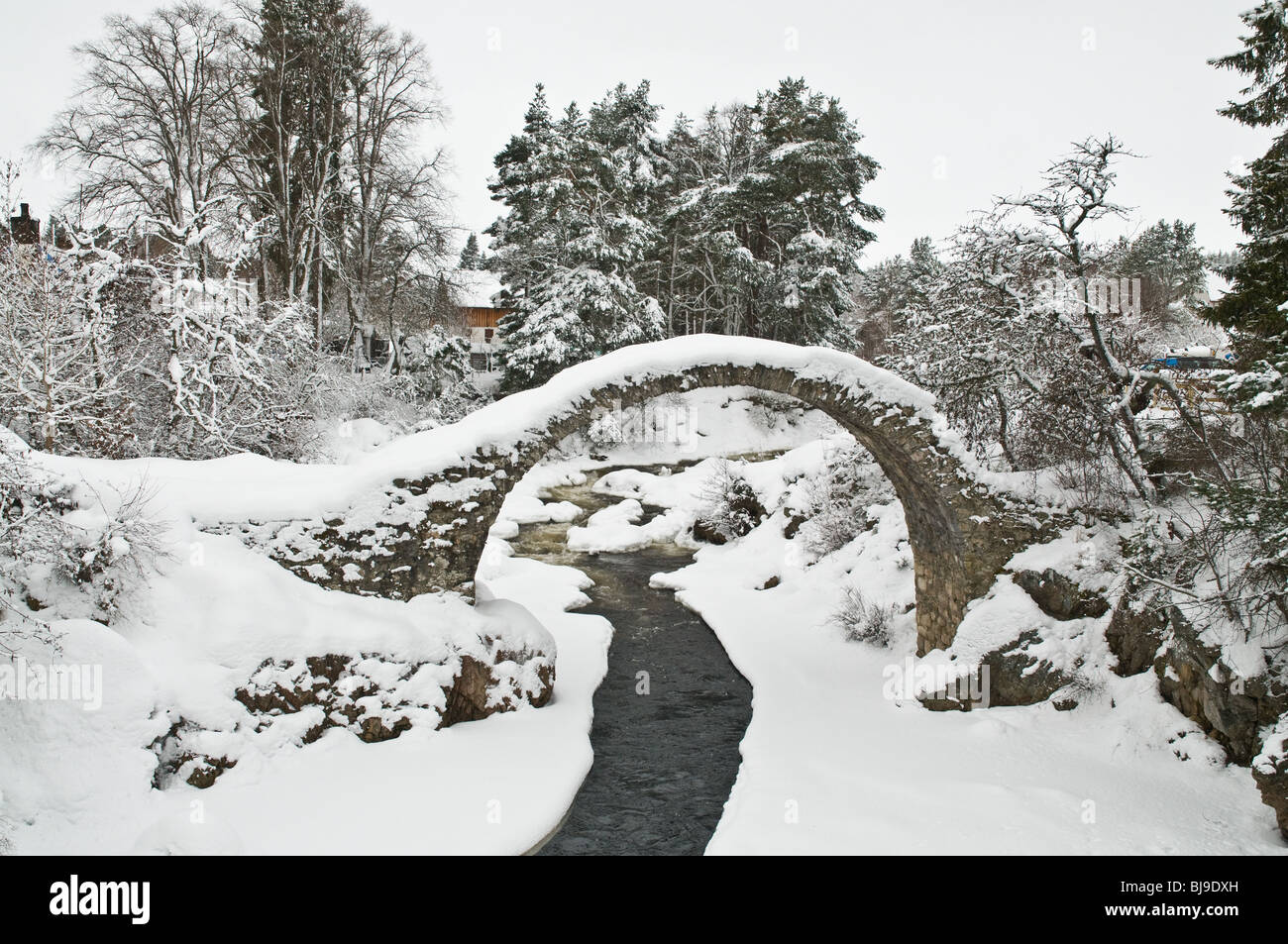 dh Dulnain River Packhorse Bridge CARRBRIDGE SCOTLAND UK Scottish Highlands Alte einspannige Brücken über der Winterschneeszene Stockfoto