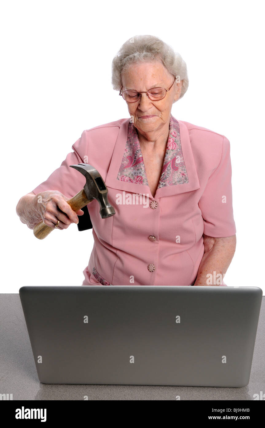 Ältere Frau brechen Laptop-Computer mit hammer Stockfoto