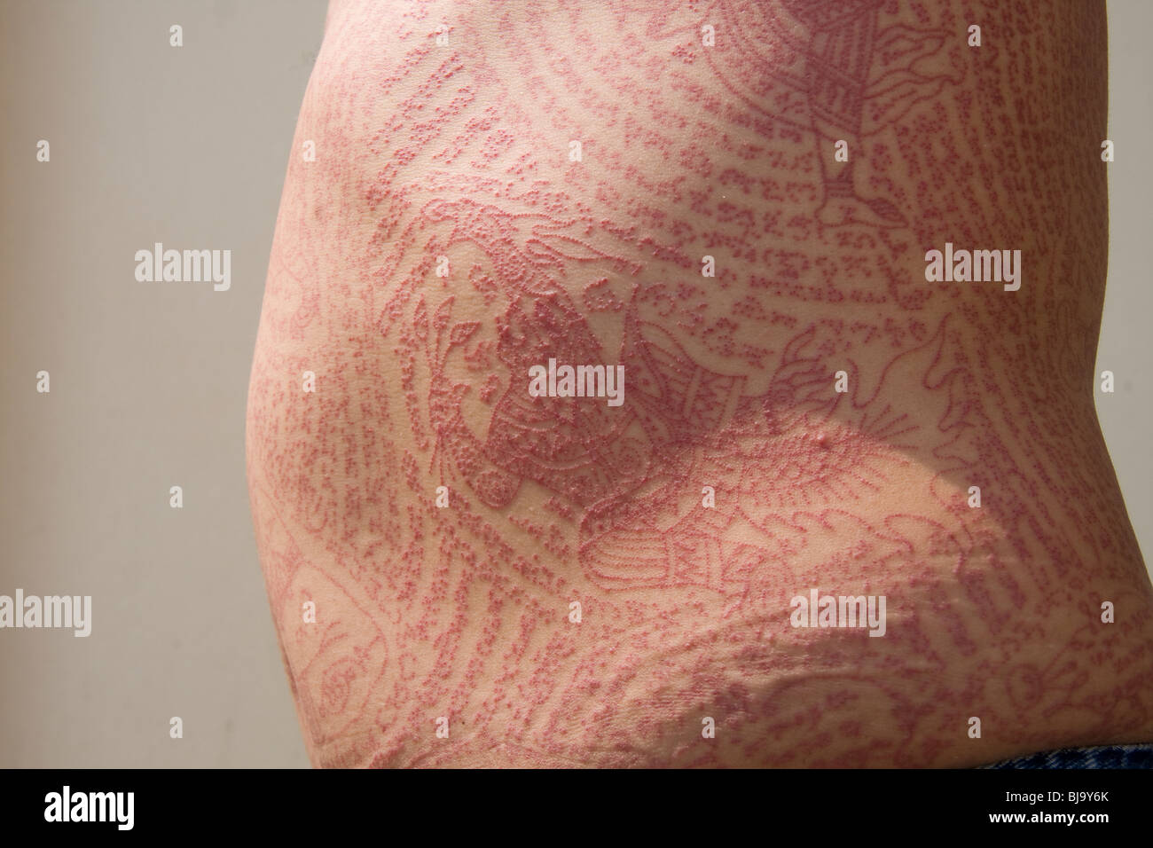 Seitenansicht von roter Tinte Tätowierungen in Wat Bang Phra-Tempel in Thailand, wo die Mönche ihren Verehrern tätowieren. Stockfoto