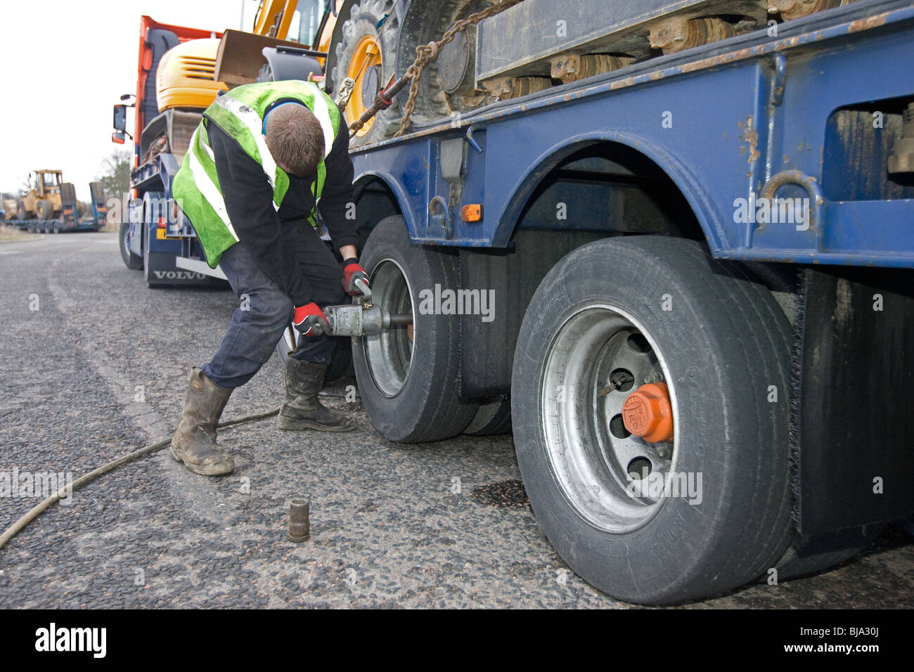 Ein Reifen Fitter arbeiten auf einem LKW-Reifen am Straßenrand geändert wird Stockfoto