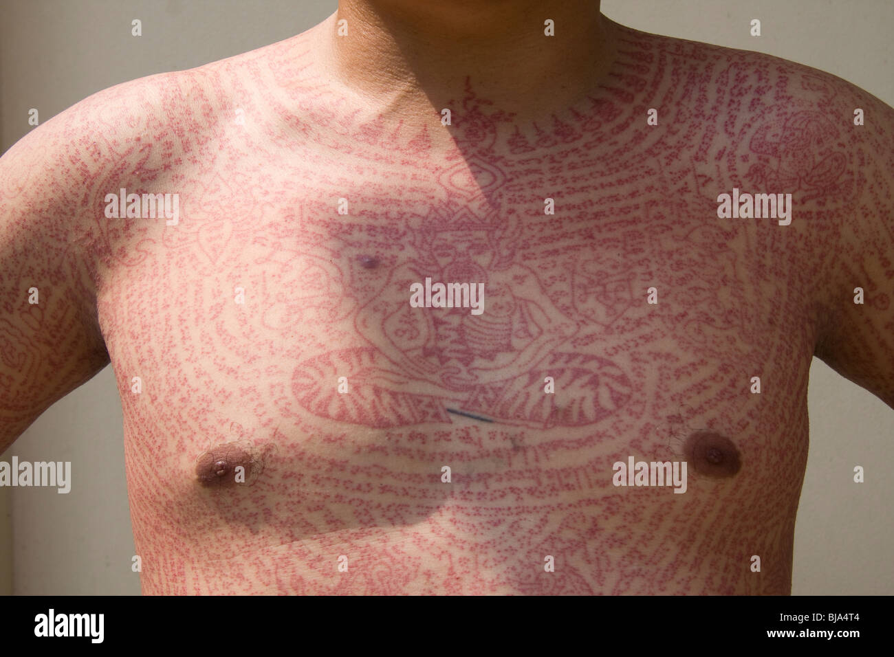 Frontansicht von roter Tinte Tätowierungen in Wat Bang Phra-Tempel in Thailand, wo die Mönche ihren Verehrern tätowieren. Stockfoto