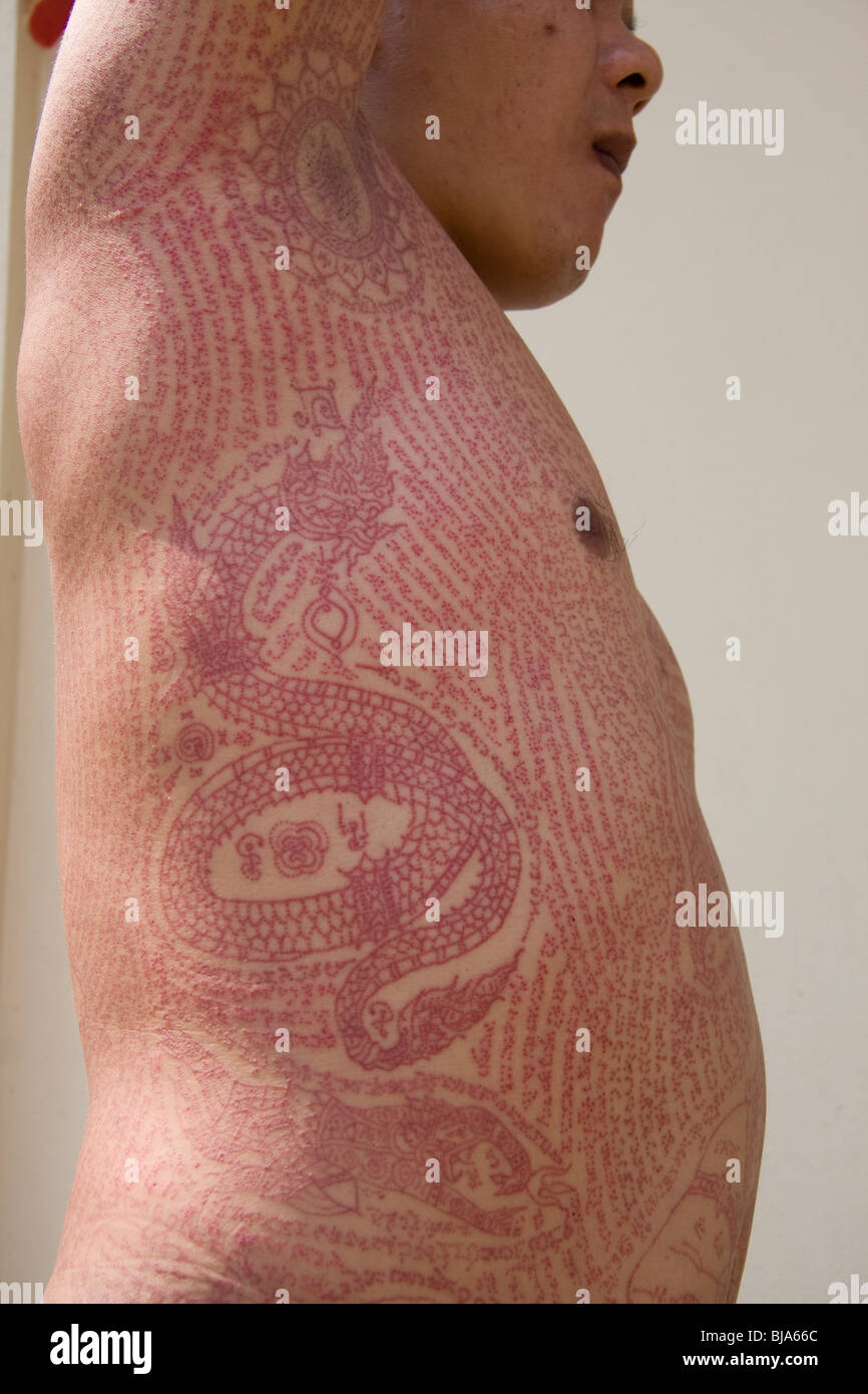 Seitenansicht von roter Tinte Tätowierungen in Wat Bang Phra-Tempel in Thailand, wo die Mönche ihren Verehrern tätowieren. Stockfoto