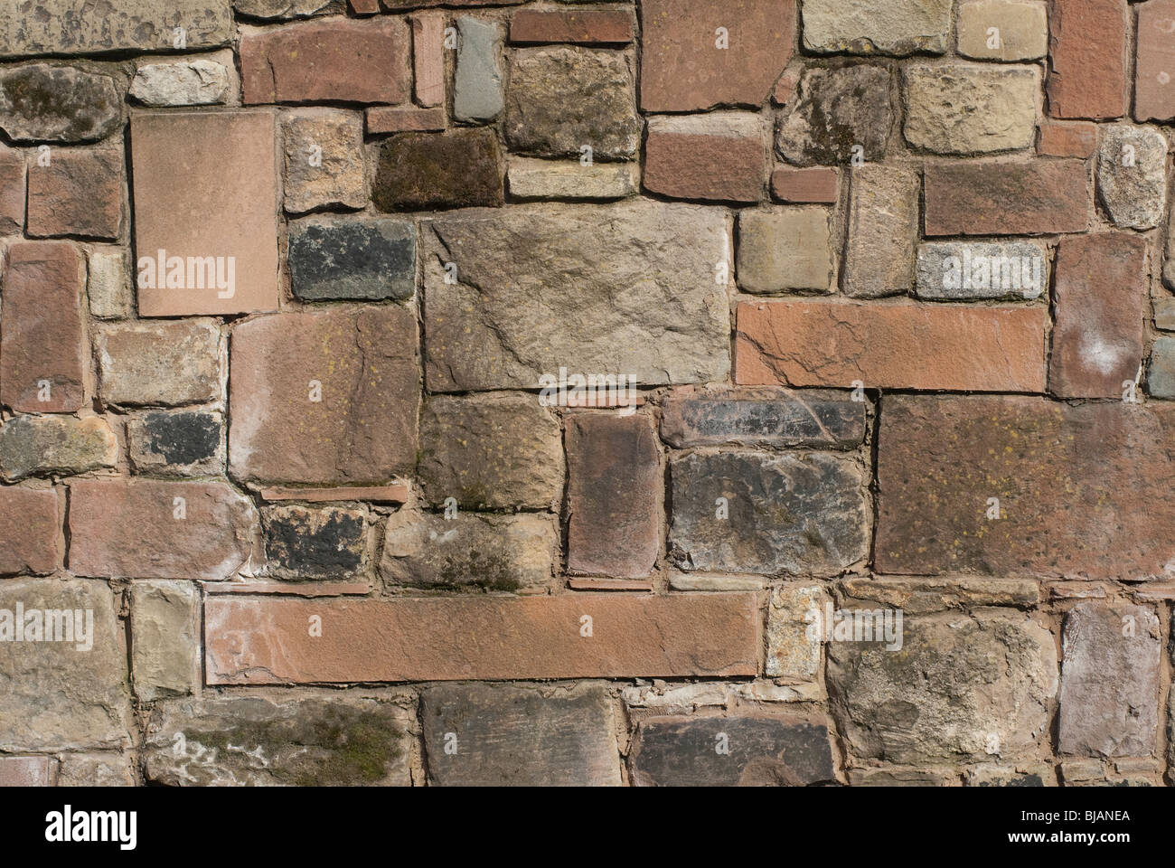 Eine solide Stein Wand aus Sandstein, Kalkstein und Granit. Stockfoto