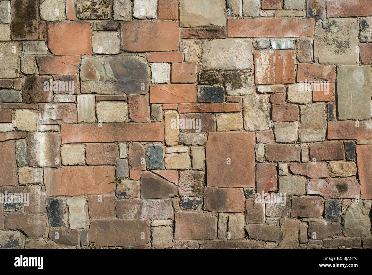 Eine solide Stein Wand aus Sandstein, Kalkstein und Granit. Stockfoto