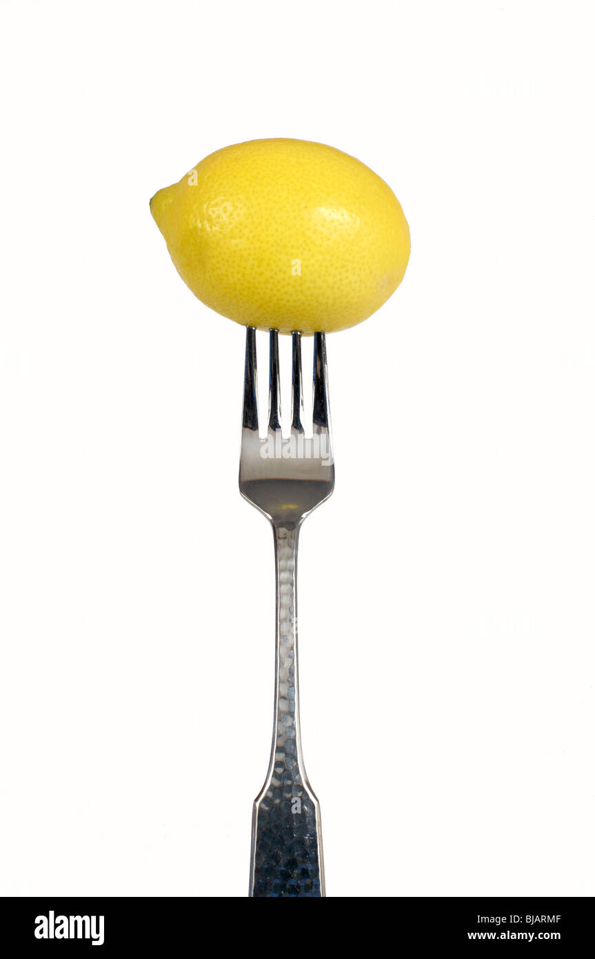 Essen auf die Gabel, A Zitrone auf einer Gabel auf einem weißen Hintergrund Stockfoto