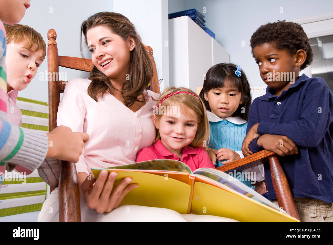 Lehrer-Lesebuch, multi-ethnischen Gruppe von jungen Kinder im Vorschulalter Stockfoto