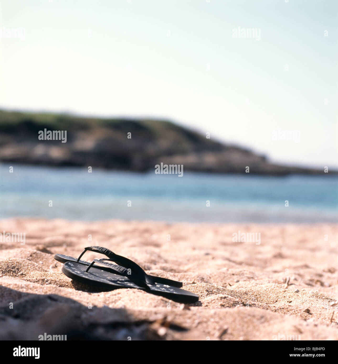 ein paar Flip-flops am Sandstrand Stockfoto