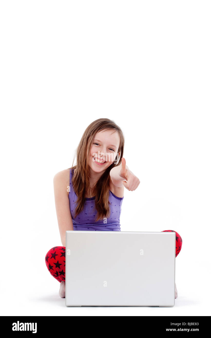 glückliches Mädchen mit Laptop Daumen auftauchen - isoliert auf weiss Stockfoto