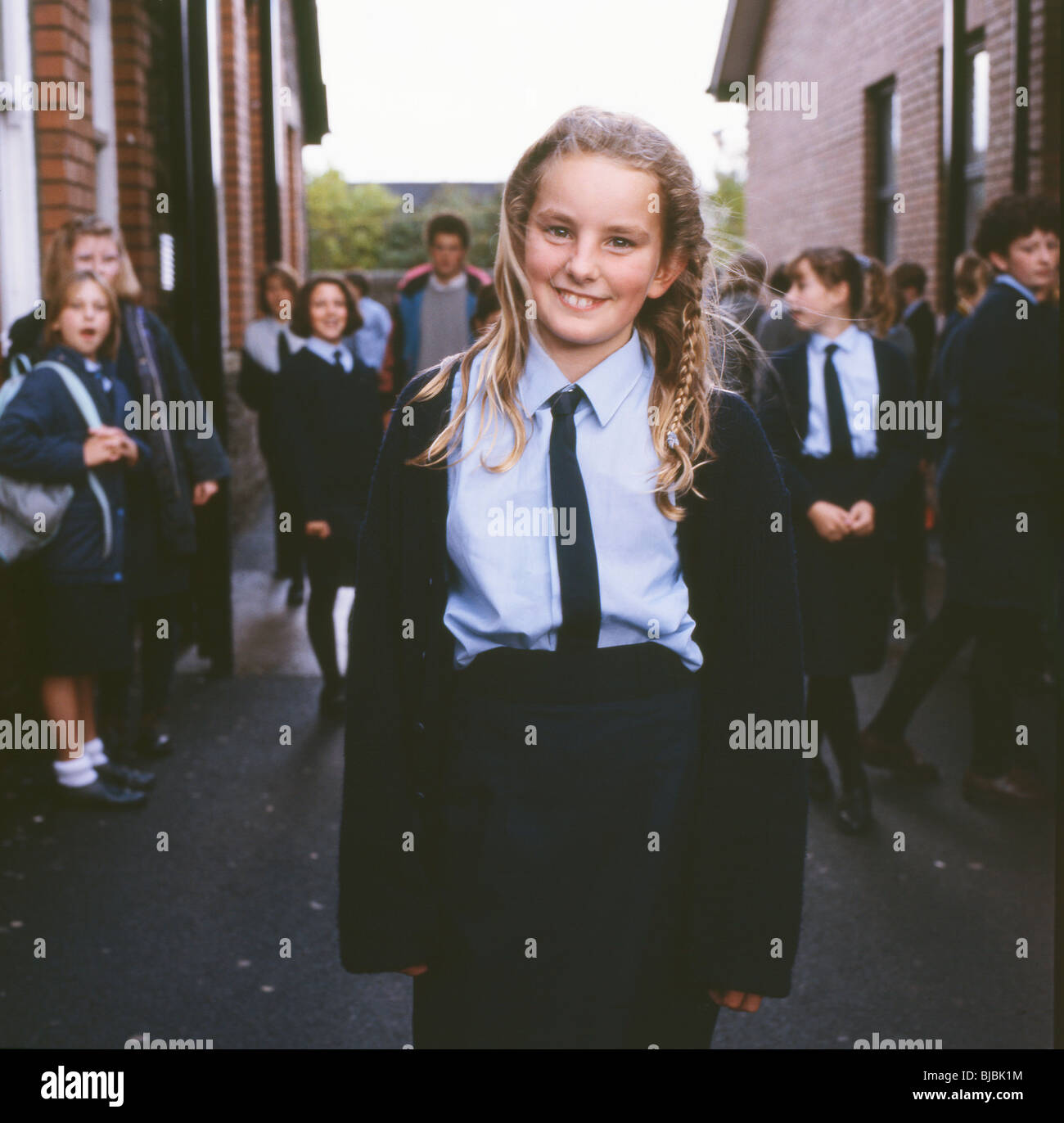 Ein lächelndes Britische sekundäre student Schülerin in Uniform außerhalb ihrer High School in Wales, UK KATHY DEWITT Stockfoto