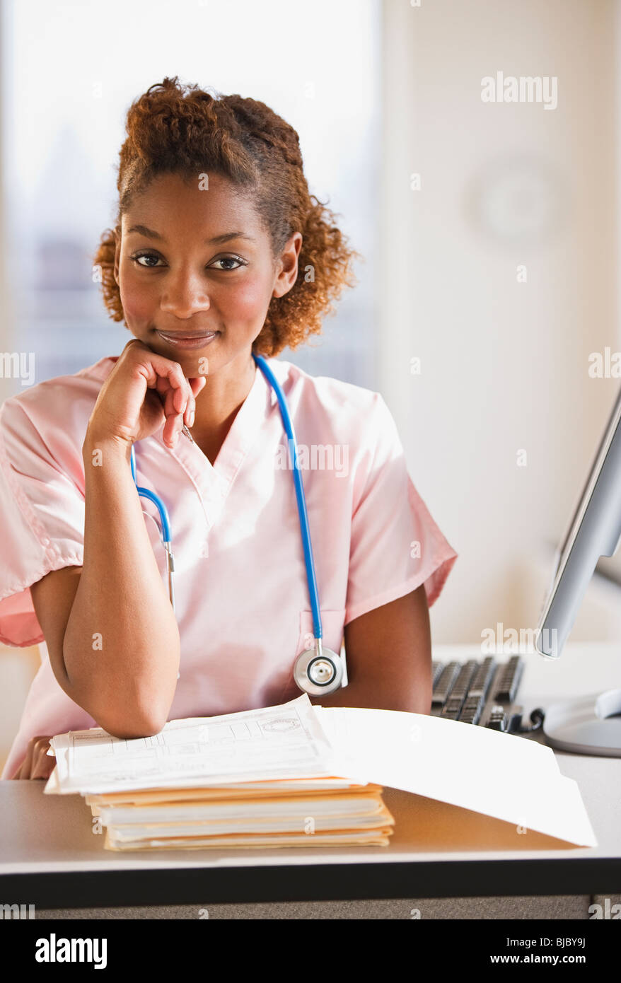 Gemischte Rassen Krankenschwester an medizinischen Diagrammen arbeiten Stockfoto