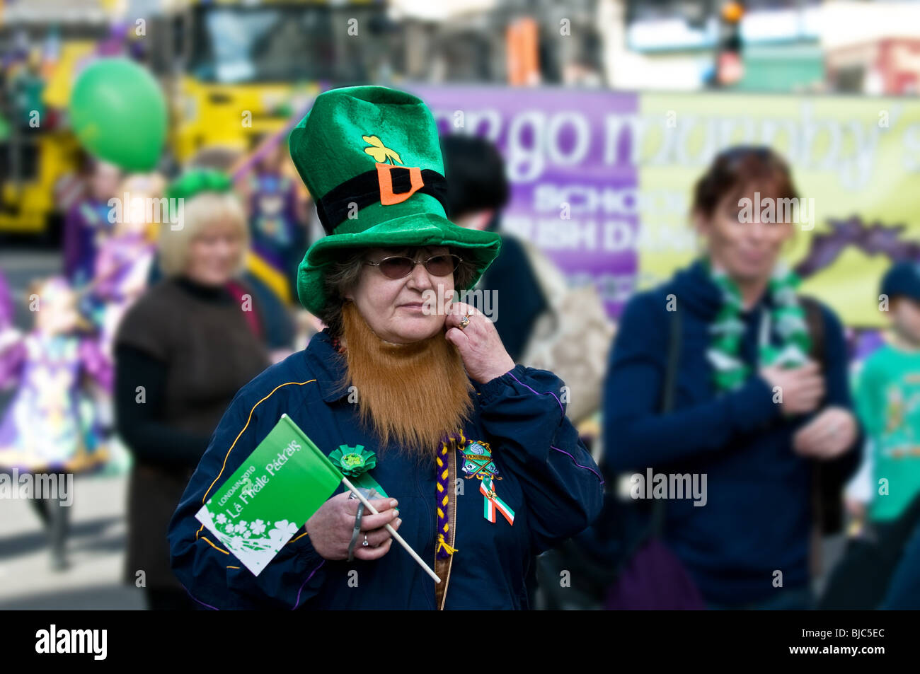 Eine Frau trägt eine Neuheit Mütze und Bart während der St Patricks Day Parade in London. Stockfoto