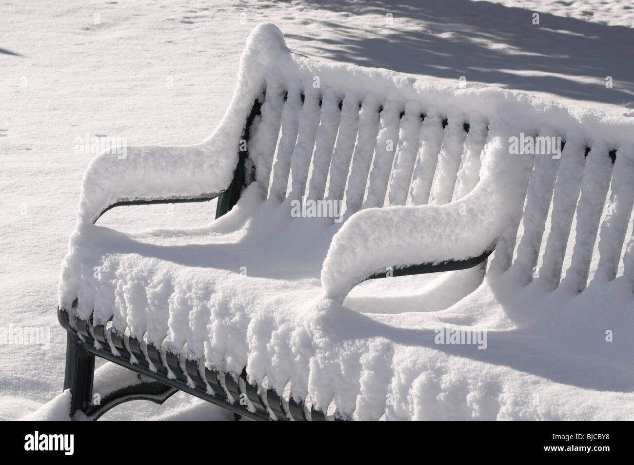 Doppelte Schmiedeeisen Bank mit Waffen im Tiefschnee im Dom Park in Santa Fe, New Mexico Stockfoto