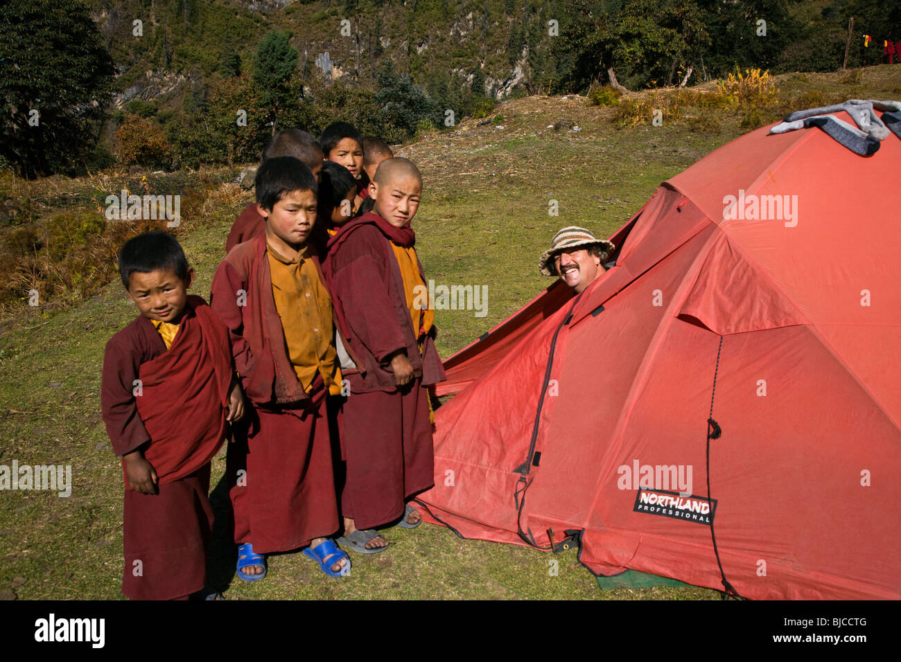 Craig Lovell springt aus seinem Zelt mit jungen Mönche in einem abgelegenen tibetischen buddhistischen Kloster - NEPAL HIMALAYA zu besuchen Stockfoto