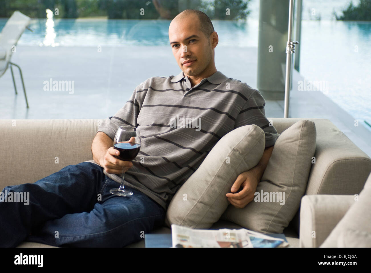 Mann auf Sofa mit Glas Wein entspannen Stockfoto