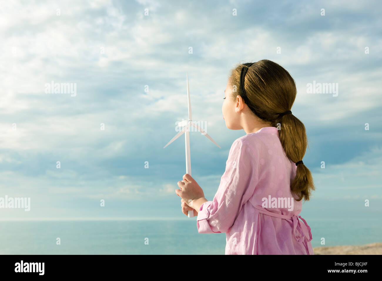 Ökologie-Konzept, Mädchen bläst auf Schaufeln Miniatur Windturbine Stockfoto