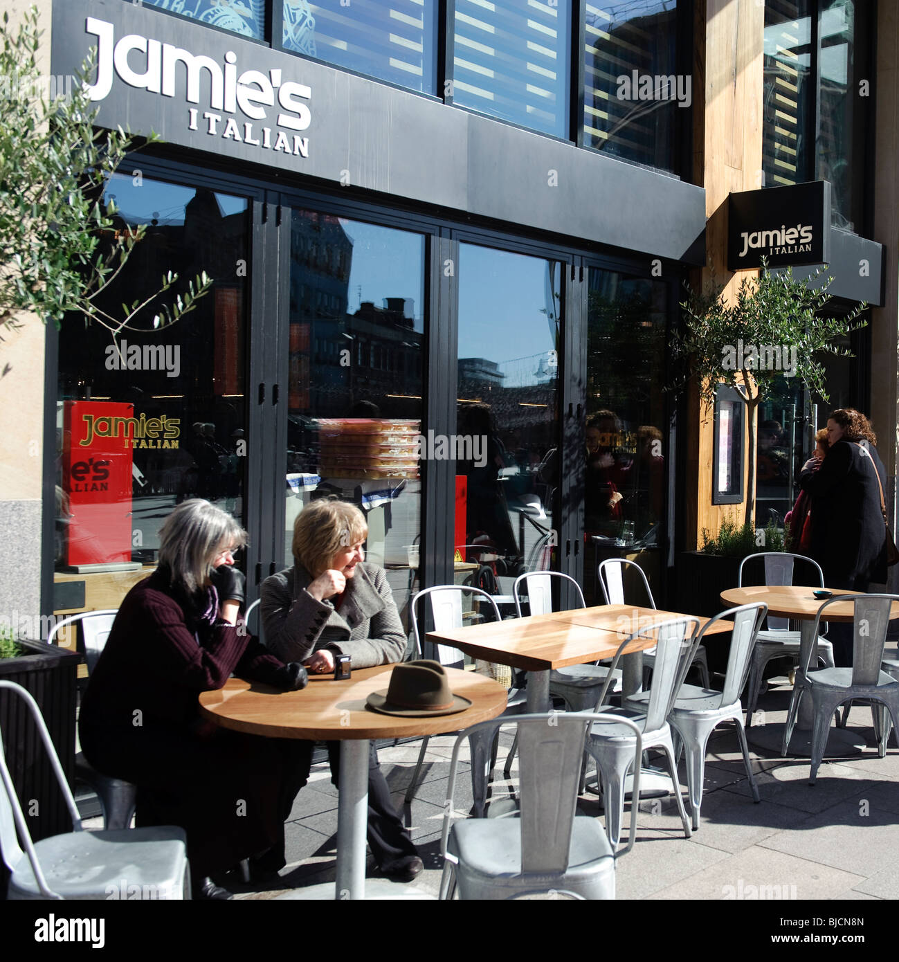 zwei Frauen sitzen am Bürgersteig Tische draußen Jamies Italienisches Restaurant, Cardiff Wales UK Stockfoto