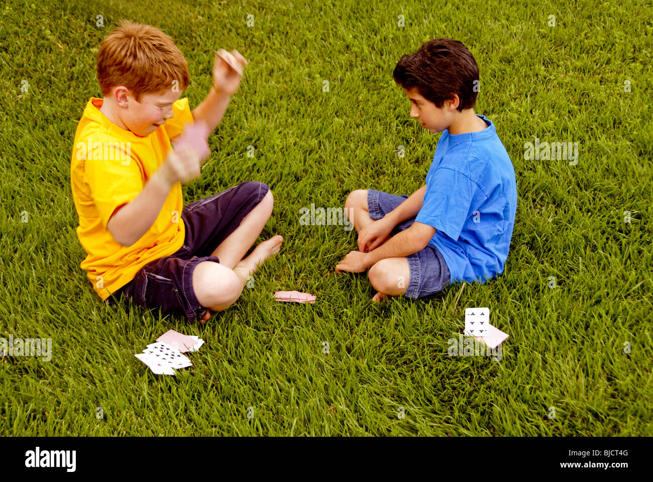 Ten-Year-Old Boys, einem kaukasischen und einem iranisch-amerikanischen, spielen Karten im Freien in Laguna Niguel, CA. Stockfoto