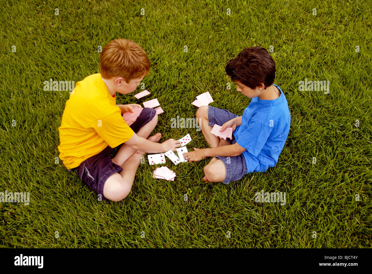 Ten-Year-Old Boys, einem kaukasischen und einem iranisch-amerikanischen, spielen Karten im Freien in Laguna Niguel, CA. Stockfoto