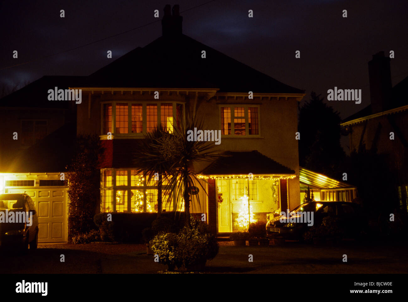 Haus mit verbleitem Lichteffekt In Windows bei Nacht Surrey England Stockfoto