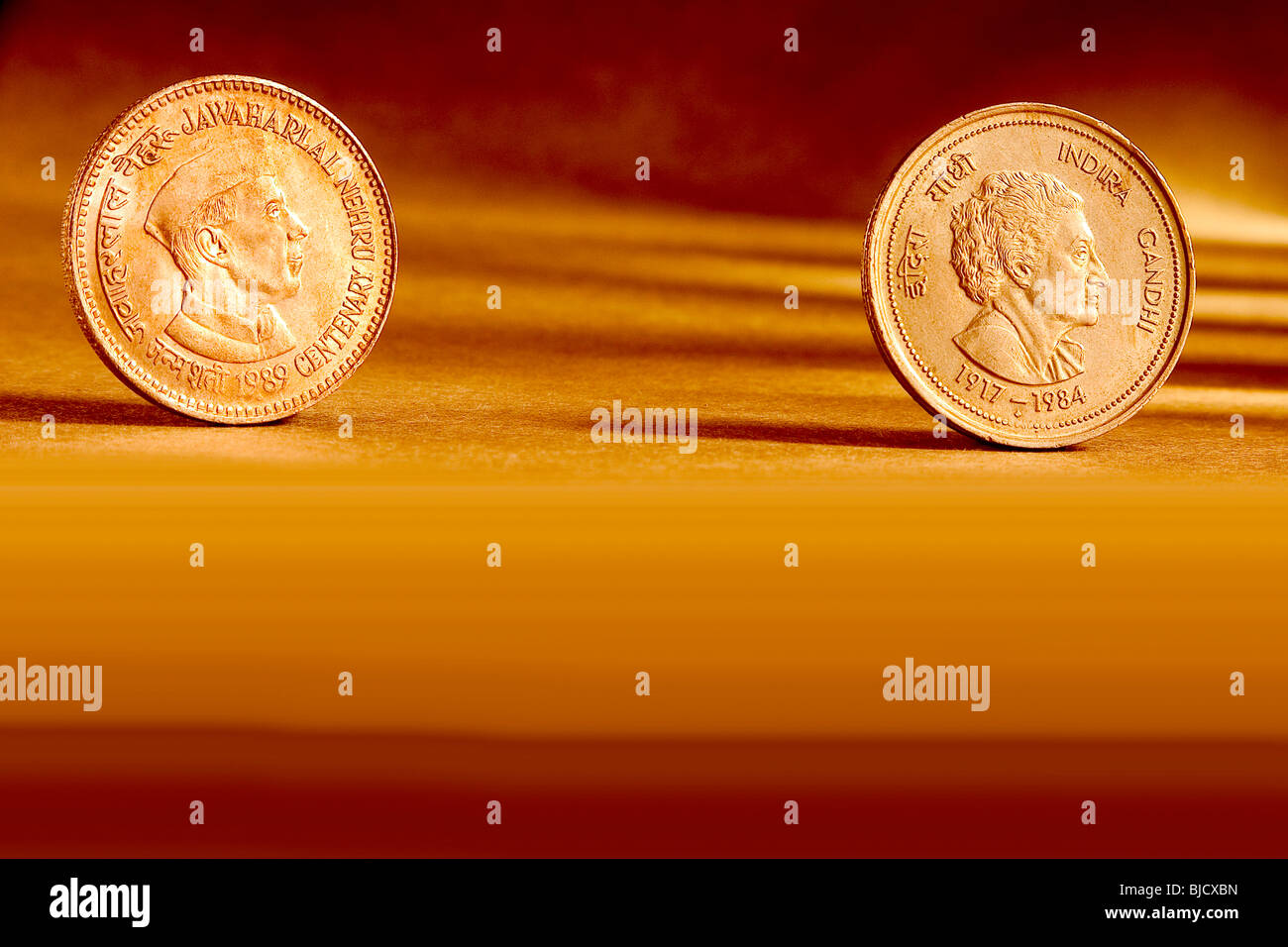 Doppeltes Paar indischer Währung fünf Rupien Münzen Jawaharlal Nehru Centenary 1989 & Indira Gandhi 1917-1984 auf orangem Hintergrund Stockfoto