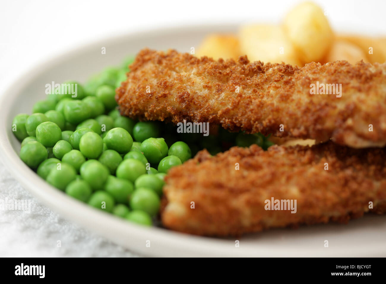 Frittierte Fischstäbchen mit Chunky Kartoffelchips und Erbsen auf Teller serviert Stockfoto