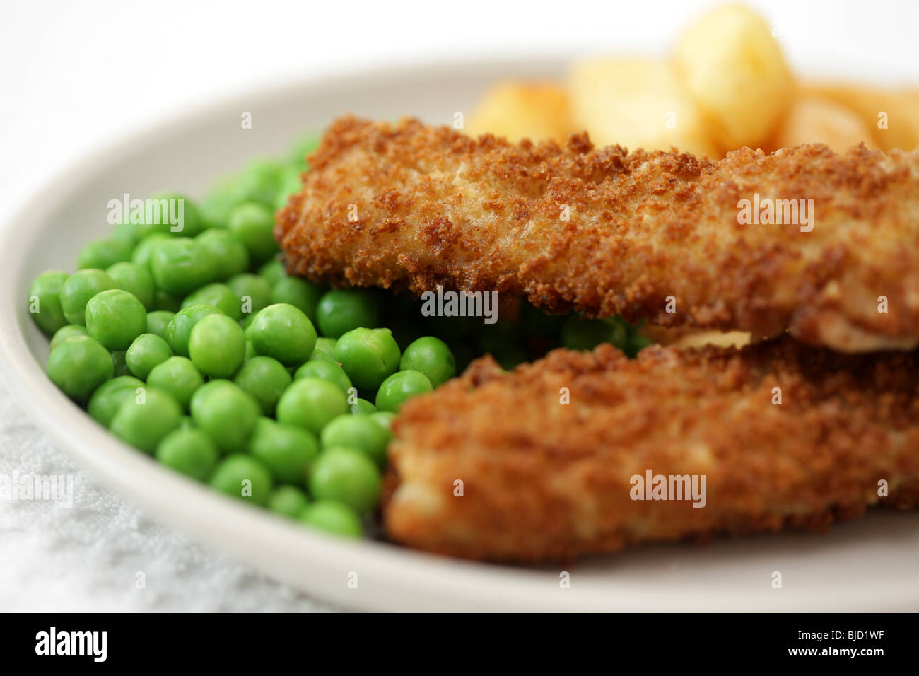 Fischstäbchen-Chips und Erbsen Stockfoto