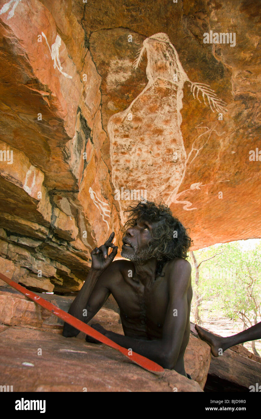 Aborigines älteste Tom Noytuna mit der Regenbogen-Schlange-Felskunst gemalt von seinem Vater Wally Mandarg an Dukaladjarrang Arnhem Land Stockfoto