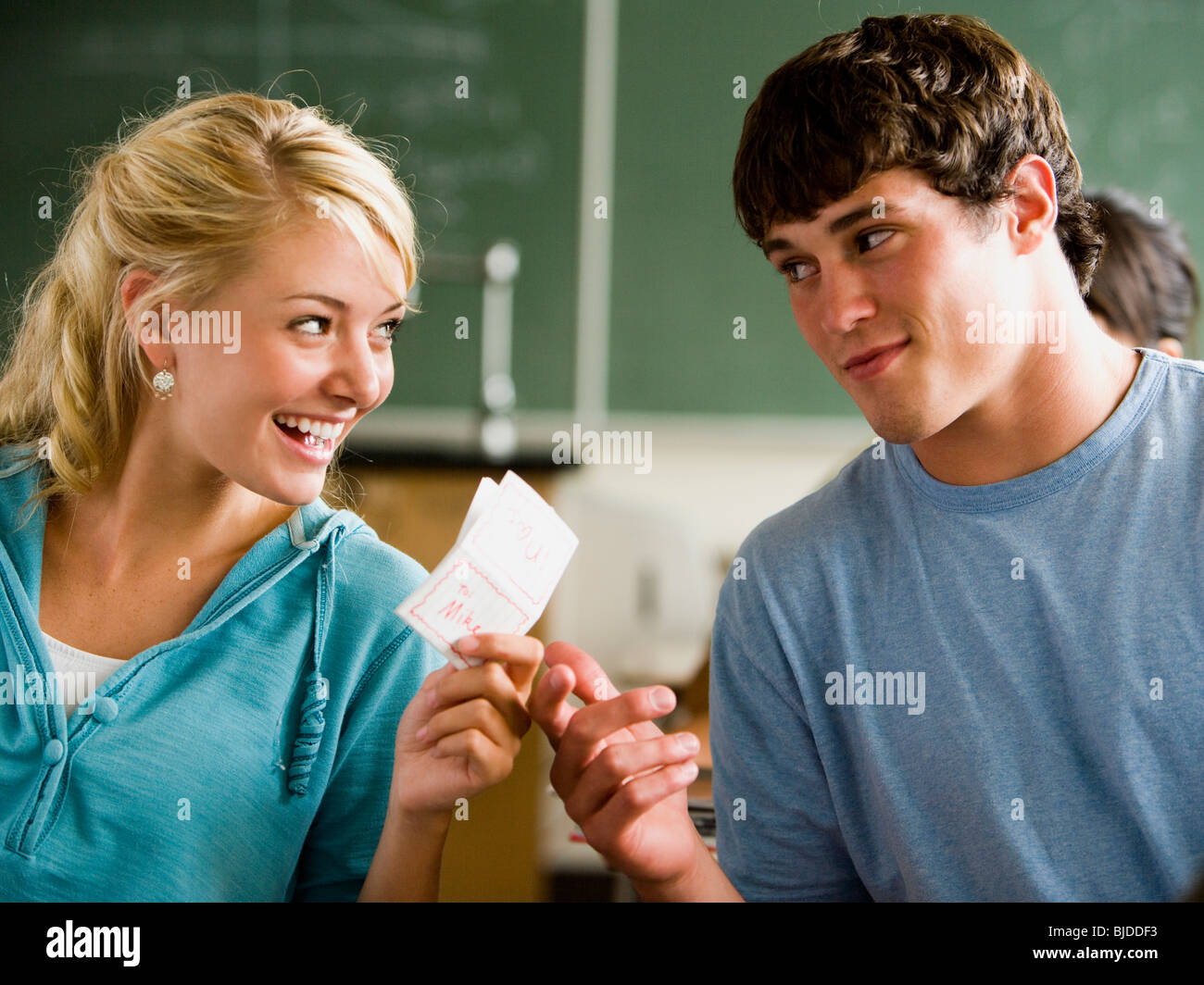 Studenten vorbei Notizen in einem Klassenzimmer. Stockfoto