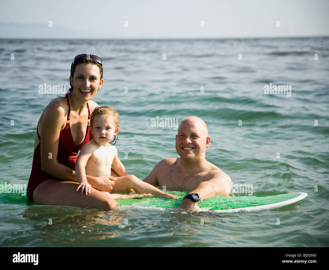 Familie im Meer auf einem Surfbrett. Stockfoto