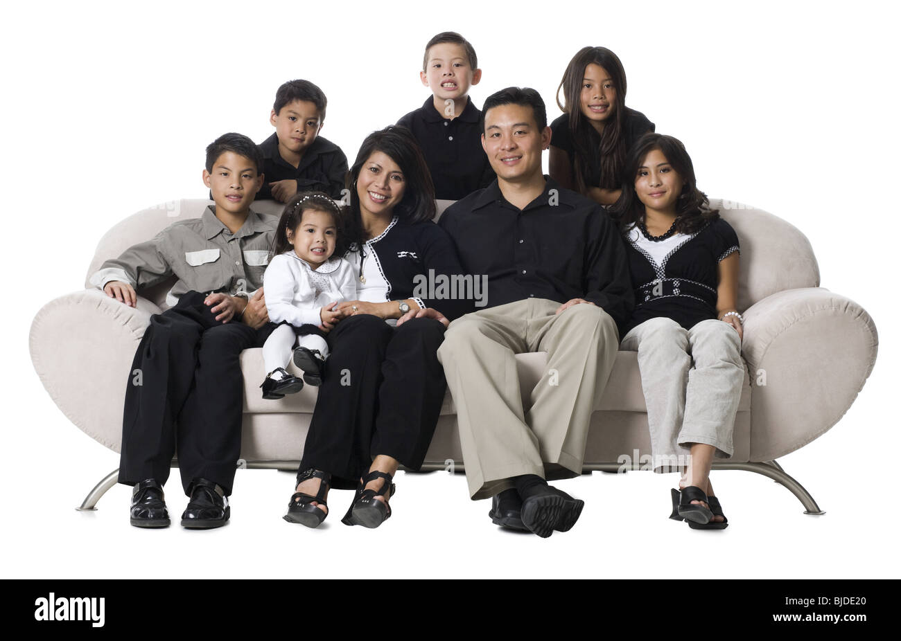 Familie sitzt auf einer Couch Lächeln auf den Lippen. Stockfoto