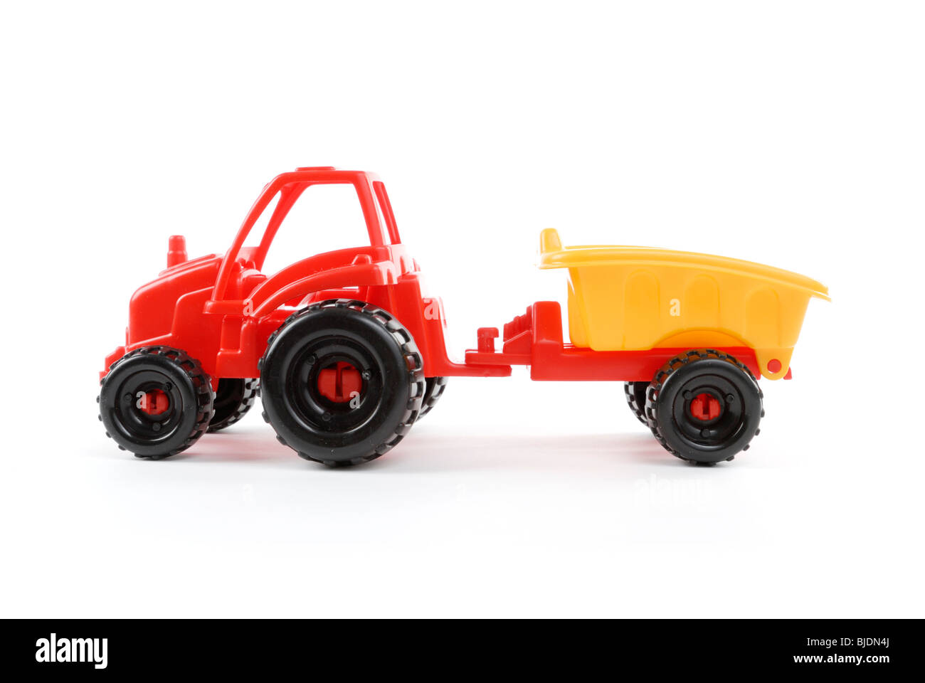 Roter Kunststoff Spielzeug-Traktor auf weißem Hintergrund Stockfoto
