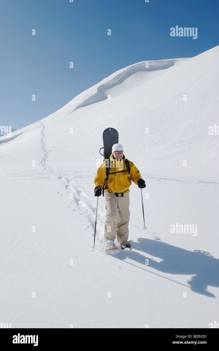 Snowboarder, Wandern mit Schneeschuhen mit seinem Brett in Off-Piste-Gelände, Chamonix, Frankreich Stockfoto
