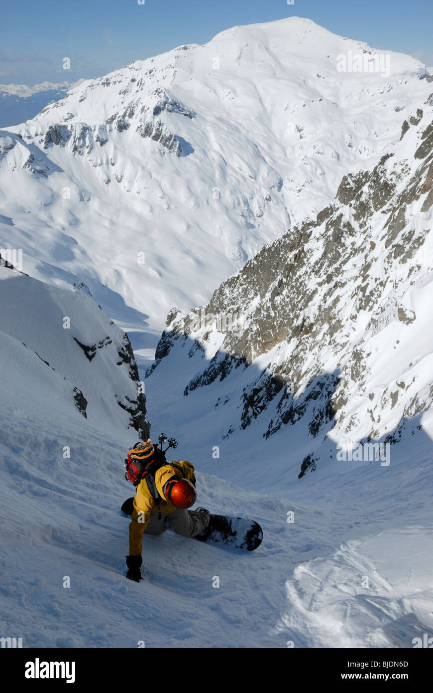 Snowboarder, die Eingabe von sehr steilen gully am Col Belvede, in der Nähe von Le Brévent-Flegere Skigebiet Chamonix, Frankreich. Mt Buet in Ferne. Stockfoto