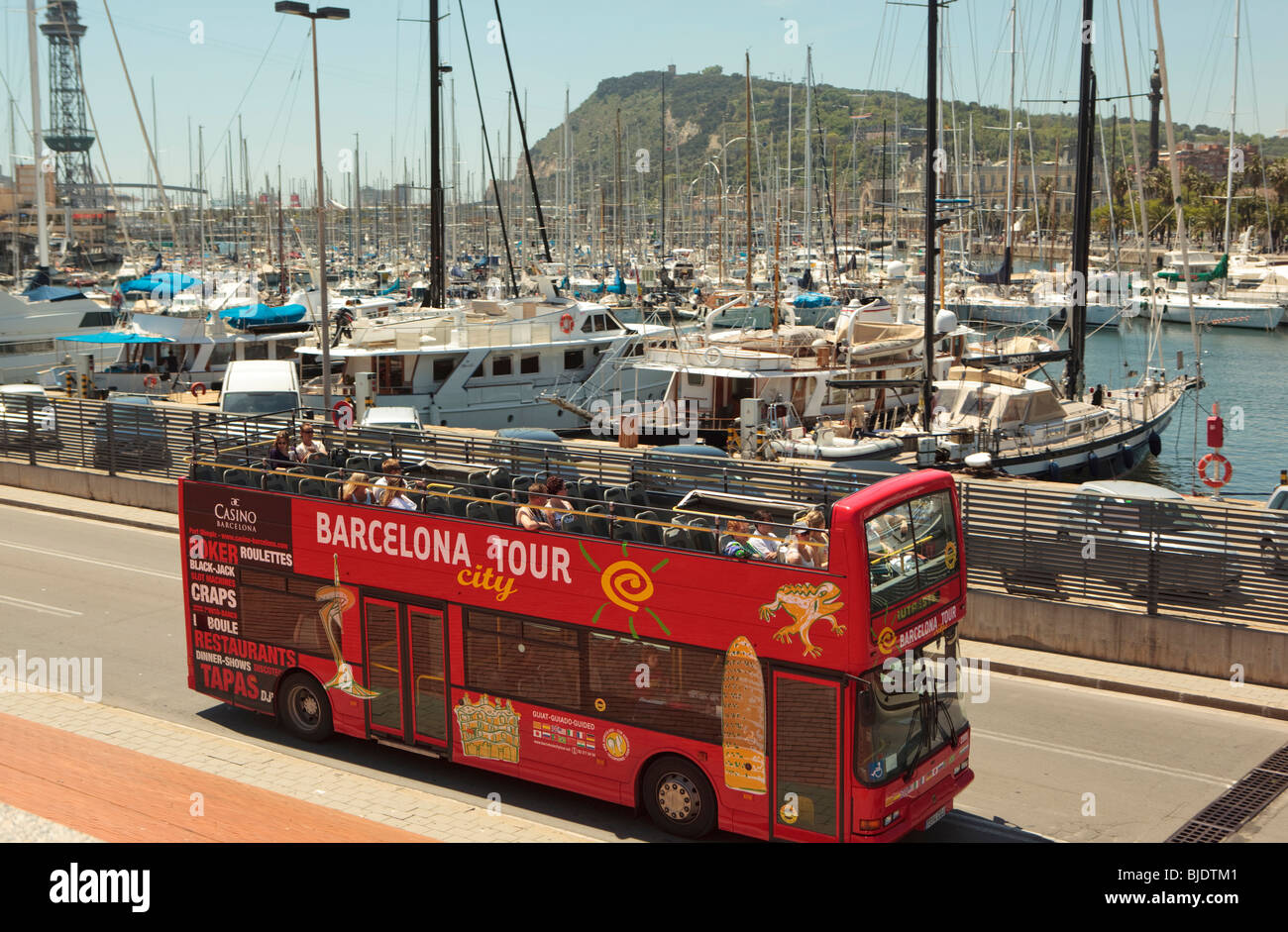 Touristen erhalten eine Oberdeck Sicht der Boote im Hafen von Barcelona aus einem roten open-Top-Tour-Bus. Stockfoto