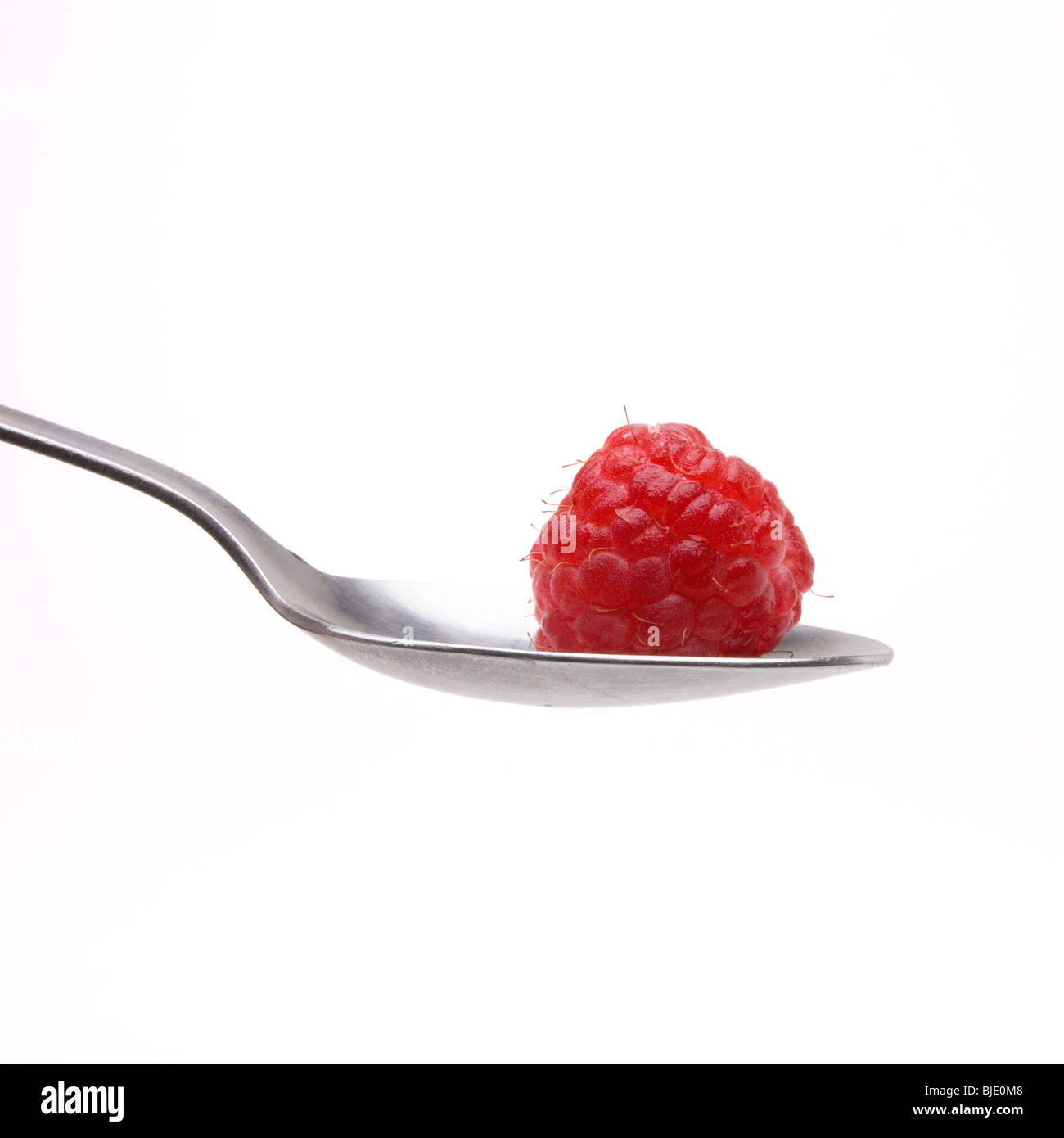 Himbeere sitzen in Schüssel mit Löffel aus Edelstahl isoliert vor weißem Hintergrund. Stockfoto