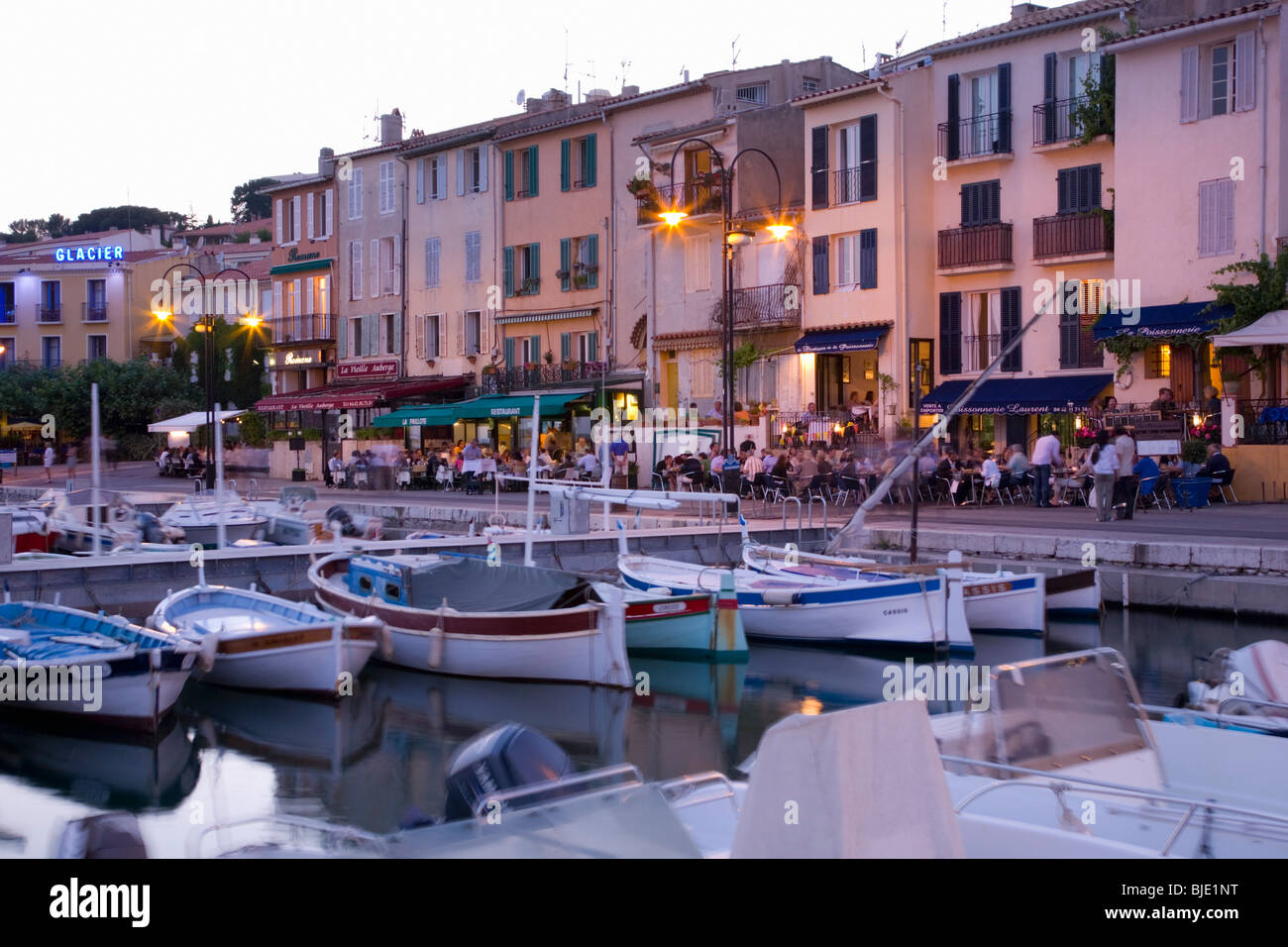 Cassis, Provence, Frankreich. Blick über den Hafen, Restaurants am Wasser in der Abenddämmerung. Stockfoto