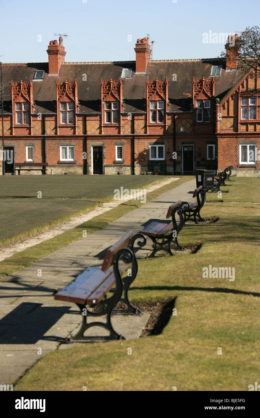 Dorf Port Sunlight, England. leere Bänke an der Port Sunlight bowling green mit Cross Street Cottages im Hintergrund. Stockfoto