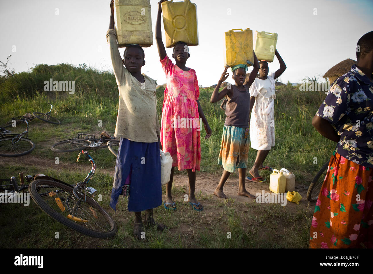 Kinder schöpfen Wasser aus einem Wasserloch in Amuria District, Uganda, Ostafrika. Stockfoto