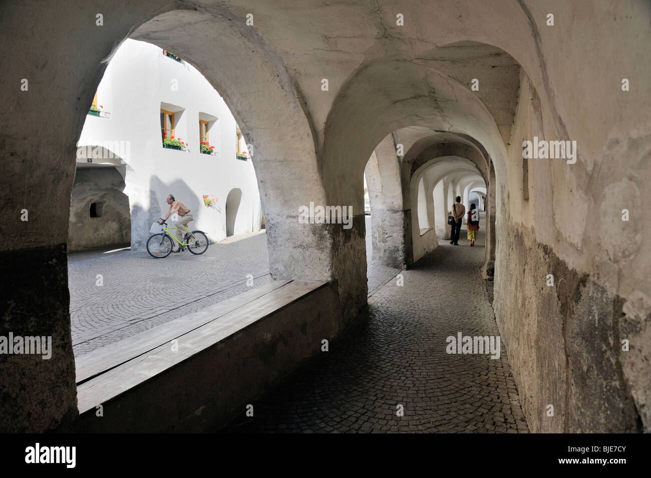 Straße in mittelalterlichen Mauern umgebene Stadt der Stadt Glurns in Val Venosta, Italienische Alpen. Arcade-überdachten Gehweg Pflaster auf Laubengasse Stockfoto