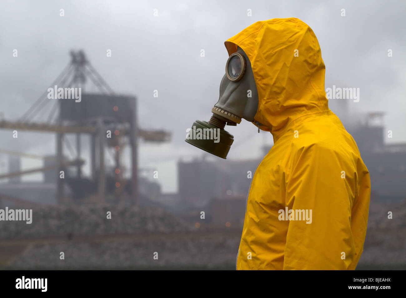 Mann mit Gasmaske stehend vor Fabrik. Frontale Aufnahme. Stockfoto