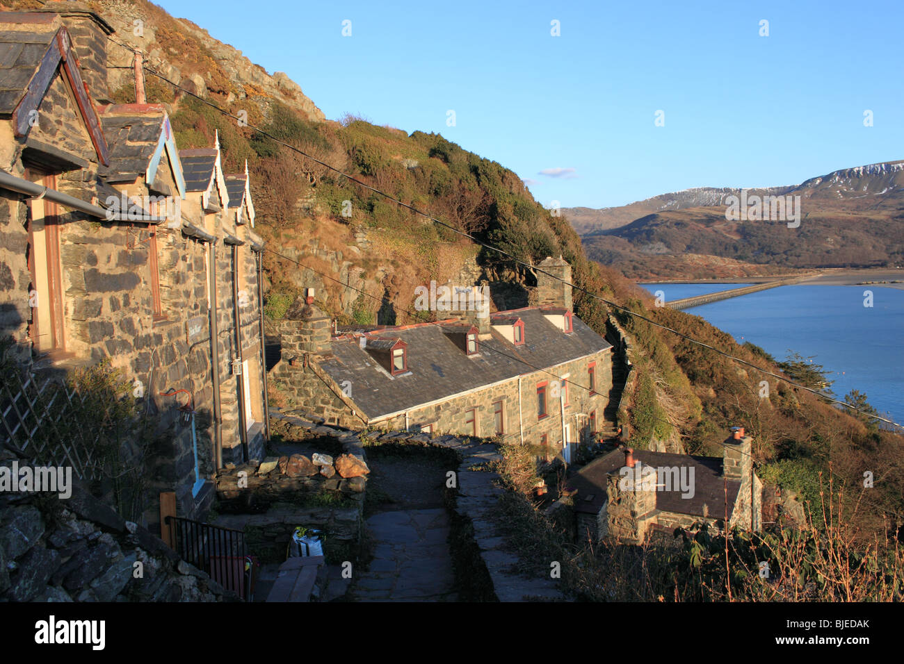 Stone Cottages Klammern sich an den Hang in den engen Straßen und Gassen des alten Barmouth. Barmouth Brücke und Cadair Idris darüber hinaus. Stockfoto