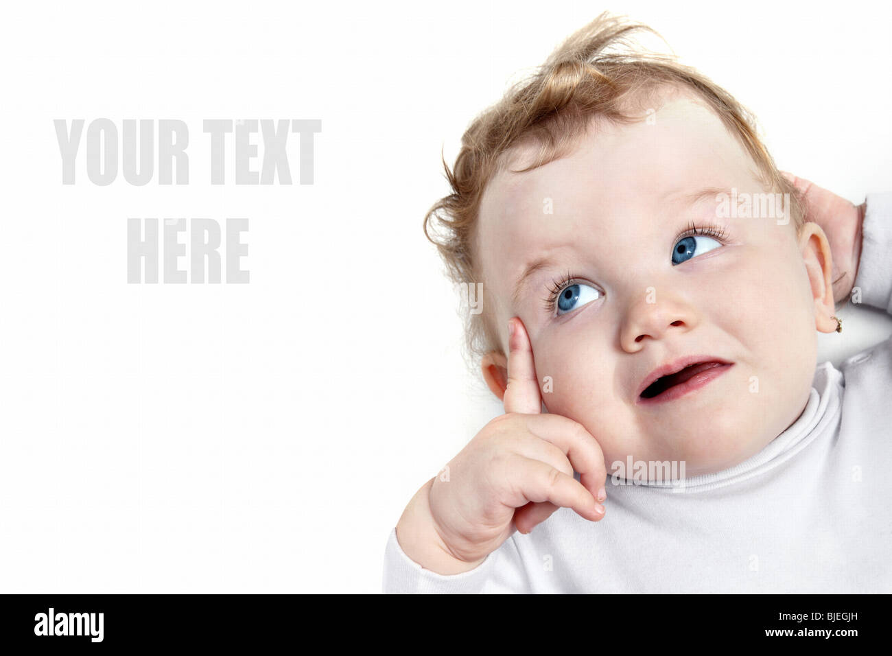 Baby mit schönen blauen Augen nach links auf etwas auf weißem Hintergrund Stockfoto