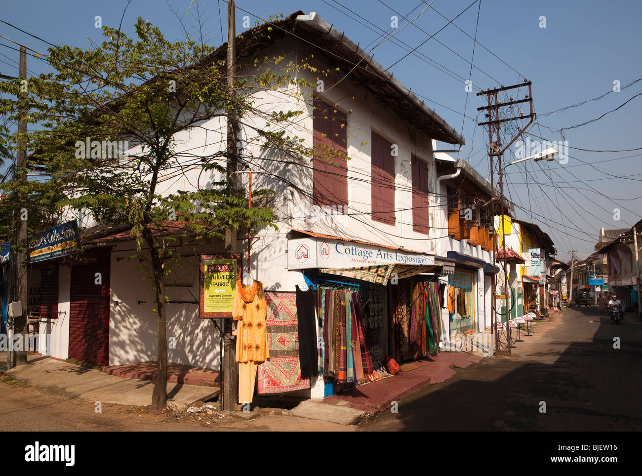 Indien, Kerala, Kochi, Mattancherry, Jewtown, Touristenläden in Straße entstellt durch elektrische Leitungen Stockfoto
