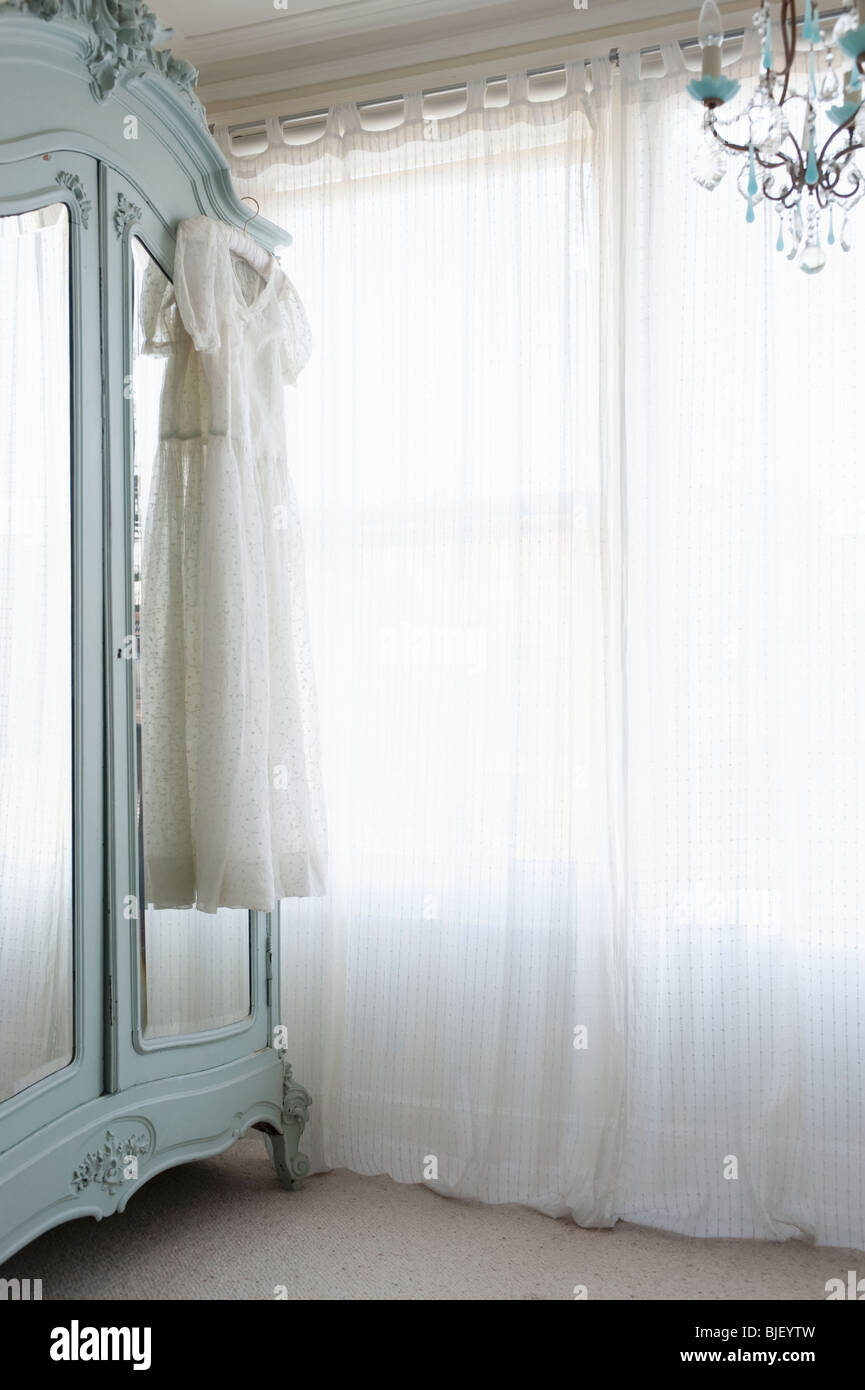 Taufe Kleid im Schrank am Fenster mit Gardinen Stockfoto