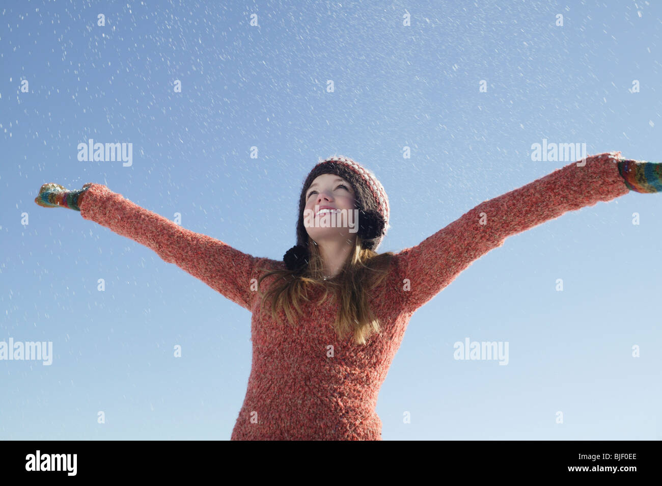 14 Jahre altes Mädchen in Winterkleidung mit ausgestreckten Armen Stockfoto