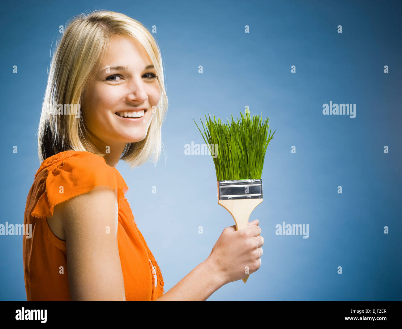 Frau mit einem Rasen-Pinsel Stockfoto